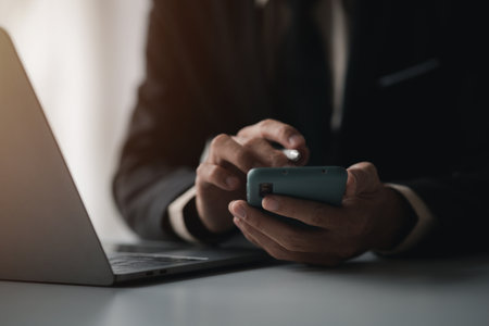 Business man looking at financial information from a mobile phone, he is checking company financial...