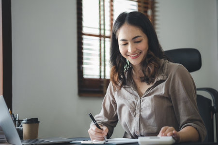 Asian women working in the office, young Asian business women as business executives, founding and running start-up executives, young female business leaders. Startup business concept.の写真素材