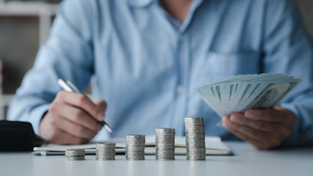 A businessman is keeping a record of his income and expenses, he plans his finances by using his monthly savings to buy funds to make it grow faster. Concept of saving money for investment.の写真素材