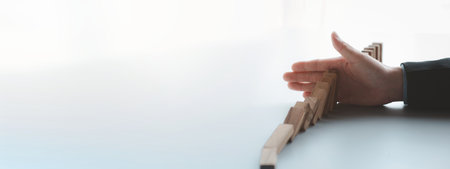 A close-up shot of a businessman holding the wooden blocks in a row, the wood blocks compare to the business risk management. The concept of risk management. copy space.の写真素材
