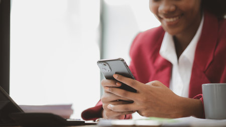 Close up american woman holding smartphone, she is using smartphone browsing social media and...