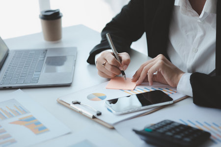 Businessman check to financial documents, he owns a startup company, he sits checking the company's financial summary prepared by the finance department. Management concept of startup company.の写真素材
