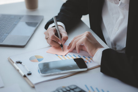 Businessman check to financial documents, he owns a startup company, he sits checking the company's financial summary prepared by the finance department. Management concept of startup company.の写真素材