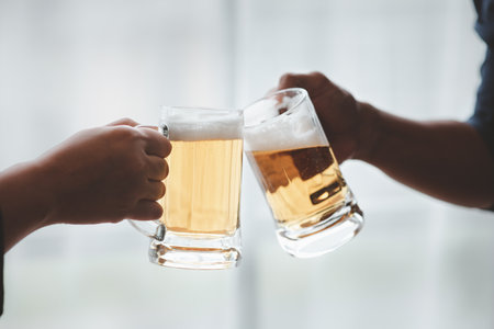 People are clinking beers together, they are partying and drinking beers together at a company party, drinking beer. Cheering with beer and And Drinking Beer.の写真素材