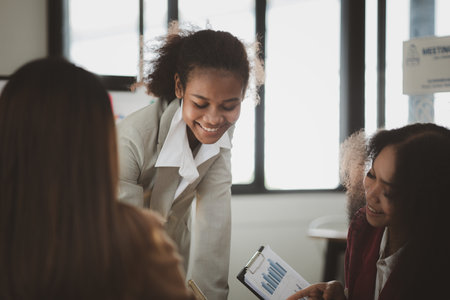 Three businesswomen are working together in the office of a startup company. They are having a...
