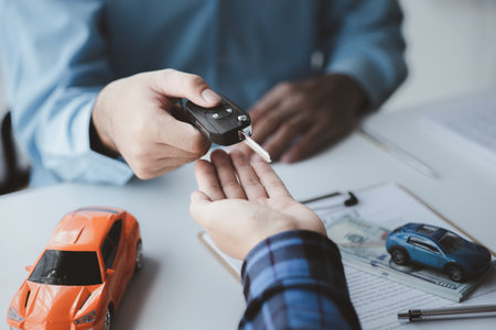 A car rental company employee pointed out the renter to sign the rental agreement after discussing...
