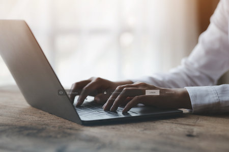 An individual is typing on a keyboard laptop showing a hologram interface to a member login, a businessman is going to access the company's membership system, check the information of the parties.の写真素材
