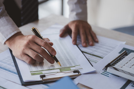 The sales department is having a monthly summary meeting to bring it to the department manager, they are verifying the correctness of the documents that are prepared before bringing in to the managerの写真素材