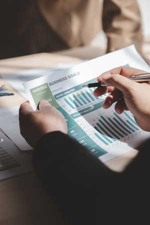 Businessman is reviewing monthly sales documents for analysis and marketing plans for more sales...