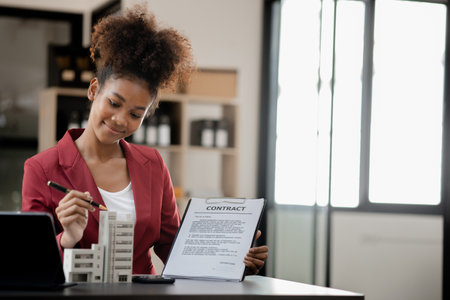 American woman sits in the office of a startup company, she is a company employee, young generation...