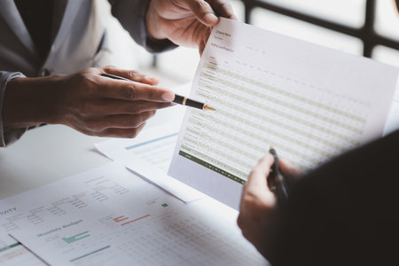 Company meeting room has businessmen and finance managers meeting together on finance topics, they are looking at information on documents and discussing together. Concept company financial managementの写真素材
