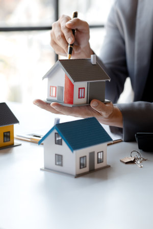Real estate agents explain models of housing estates in projects to elaborate to clients, explaining and presenting information about homes and purchasing loans. Real estate trading concept.の写真素材