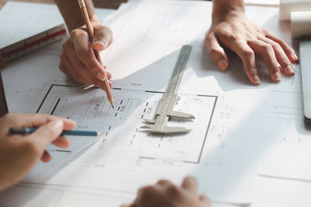 Architects and engineers are working together to edit the draft house plan that was designed after...