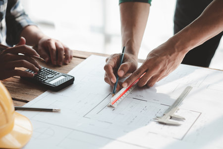 Architects and engineers are working together to edit the draft house plan that was designed after...