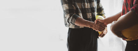 Team engineers and architects shake hands with the condo project owners after the meeting to present room plans and details of the condo building structure. Concept of building design and constructionの写真素材
