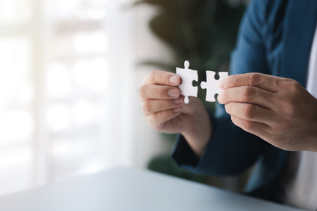 Man holding two jigsaw puzzles put together, business management concept and business risk management. Business solutions, success and strategy concept.の写真素材
