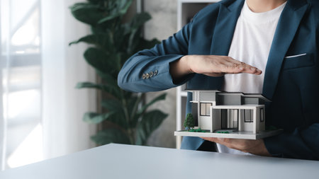 The salesperson of the housing estate in the project is preparing and verifying the contract of sale for the customer who will enter the contract. Concept of selling housing estates and real estate.の写真素材