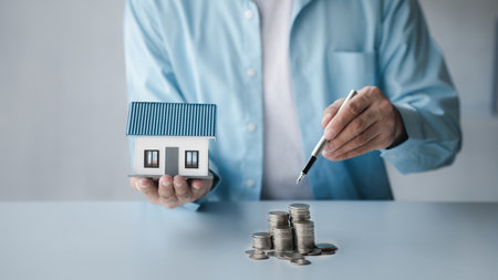 Person with stack of coins, saving money concept for future use and financial stability, savings for housing, payroll management, personal finance, investment savings.の写真素材