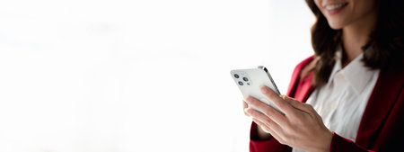 young businesswoman looking at financial information from a mobile phone, she is checking company financial documents, she is a female executive of a startup company. Concept of financial management.の写真素材