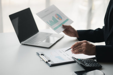 Business men are looking at the company's financial documents to analyze problems and find solutions before bringing the information to a meeting with a partner. Financial concept.の写真素材