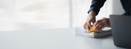 Businessman sorting stacks of department meeting papers, document management in corporate office. Office document management and storage concept.の写真素材