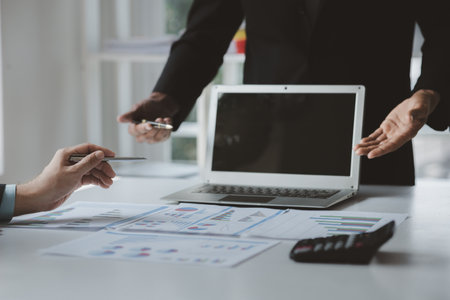 Two businessmen are brainstorming together and reviewing the company financial documents that the finance department has summarized, they are business partners. Business administration concept.の写真素材