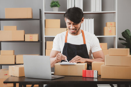 An Asian man owns an online store, he is an internet store operator selling products through an online shopping platform. The concept of selling goods and services on the internet.の写真素材