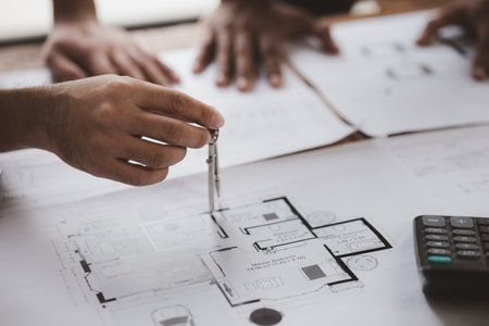 Architects and engineers are working together to edit the draft house plan that was designed after...