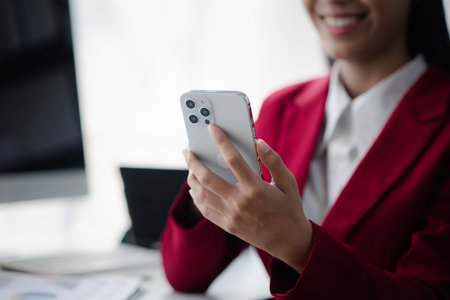Businesswoman holding mobile phone, Asian business woman owner conducts financial management, she set up startup company, modern female leader. Business woman leader concept.の写真素材