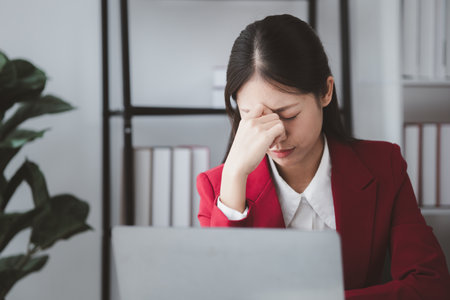 Businesswoman suffering from stress and office syndrome, Asian business owner runs finance management, she set up startup company, modern female leadership. Business woman leader concept.の写真素材