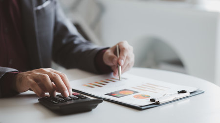 A financier is reviewing company financial documents, monthly financial statement summary from the...