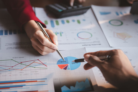 Group business people are brainstorming together and reviewing the company financial documents that...