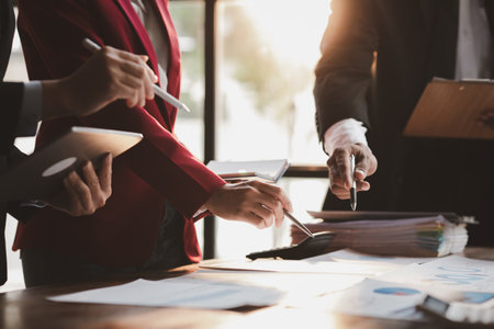 Group business people are reviewing monthly sales documents analysis and marketing plans for more sales growth, they are the founders of young companies co-founding startups. Sales management concept.の写真素材