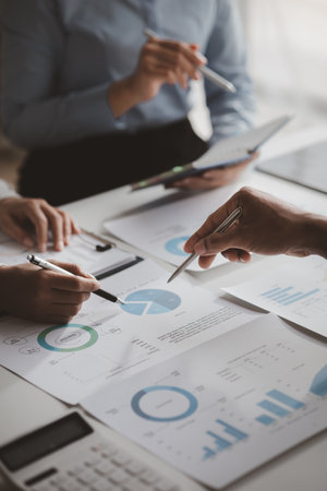 Company meeting room has businessmen and finance managers meeting together on finance topics, they are looking at information on documents and discussing together. Concept company financial managementの写真素材