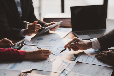 Group business people are brainstorming together and reviewing the company financial documents that the finance department has summarized, they are business partners. Business administration concept.の写真素材