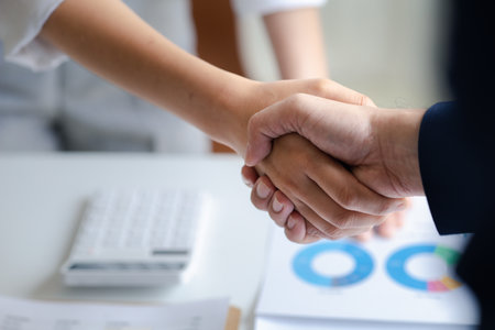 Business investor group holding hands, Two businessmen are agreeing on business together and shaking hands after a successful negotiation. Handshaking is a Western greeting or congratulation.の写真素材