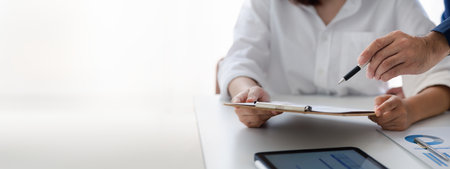 Company meeting room has businessmen and finance managers meeting together on finance topics, they are looking at information on documents and discussing together. Concept company financial managementの写真素材