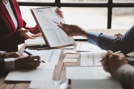 The sales department is having a monthly summary meeting to bring it to the department manager, they are verifying the correctness of the documents that are prepared before bringing in to the manager.の写真素材