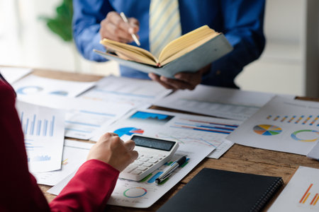 Two businessmen are reviewing monthly sales documents for analysis and marketing plans for more sales growth, they are the founders of young companies co-founding startups. Sales management concept.の写真素材