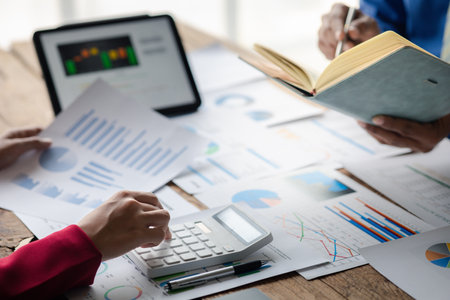 Two businessmen are reviewing monthly sales documents for analysis and marketing plans for more sales growth, they are the founders of young companies co-founding startups. Sales management concept.の写真素材