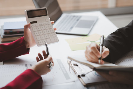 Two businessmen are brainstorming together and reviewing the company financial documents that the finance department has summarized, they are business partners. Business administration concept.の写真素材