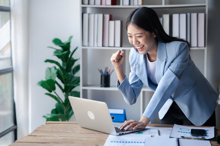 A businesswoman is checking company financial documents and using a tablet to talk to the chief financial officer through a messaging program. Concept of company financial management.の写真素材