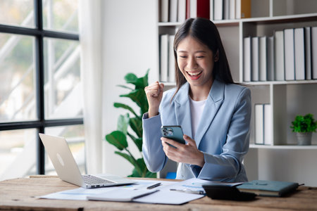 A businesswoman is checking company financial documents and using a tablet to talk to the chief financial officer through a messaging program. Concept of company financial management.の写真素材