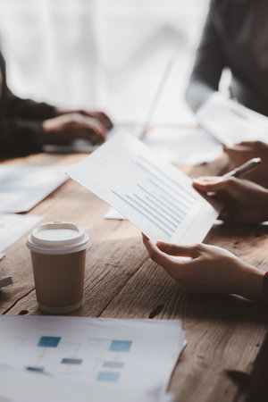 Businessman is reviewing monthly sales documents for analysis and marketing plans for more sales growth, they are the founders of young companies co-founding startups. Sales management concept.の写真素材
