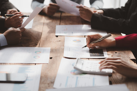 Businessman is reviewing monthly sales documents for analysis and marketing plans for more sales growth, they are the founders of young companies co-founding startups. Sales management concept.の写真素材