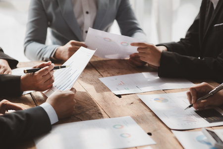 Businessman is reviewing monthly sales documents for analysis and marketing plans for more sales...