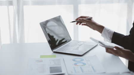 Person pointing at laptop screen, businessman sitting at company, looking at financial information on laptop summarized by the finance department. Concept of financial management.の写真素材