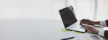 A business women working in a private room, He is typing on a laptop keyboard, He uses a messenger to chat with a partner. Concept of using technology in communication.の写真素材