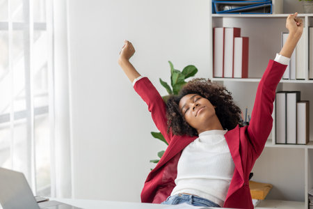 A young American woman is a start-up businesswoman, she sits in the office and is relaxing, managing and running her business from a new generation. Startup business management concept.の写真素材
