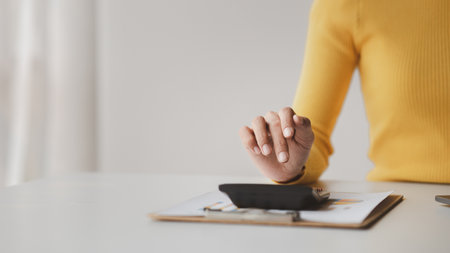 Businessman using a calculator to calculate numbers on a company's financial documents, she is analyzing historical financial data to plan how to grow the company. Financial concept.の写真素材